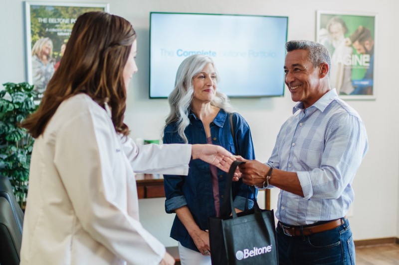 man receiving hearing aids from audiologist